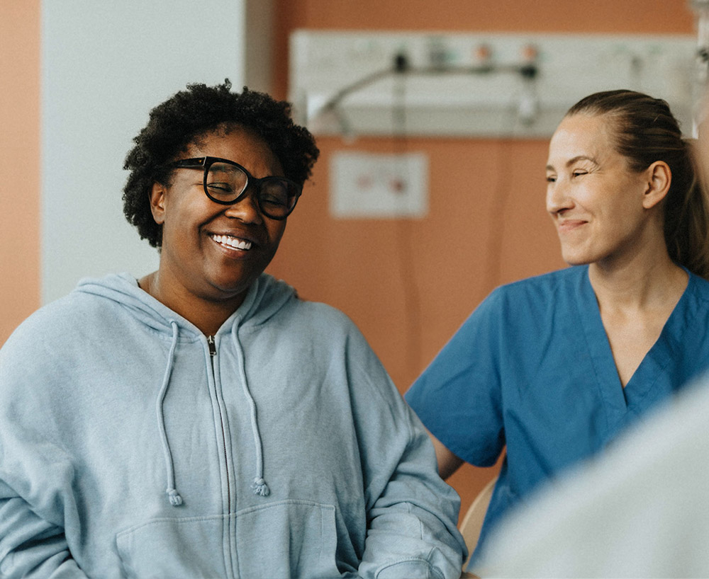 A female patient feeling relieved speaking with a nurse and doctor.